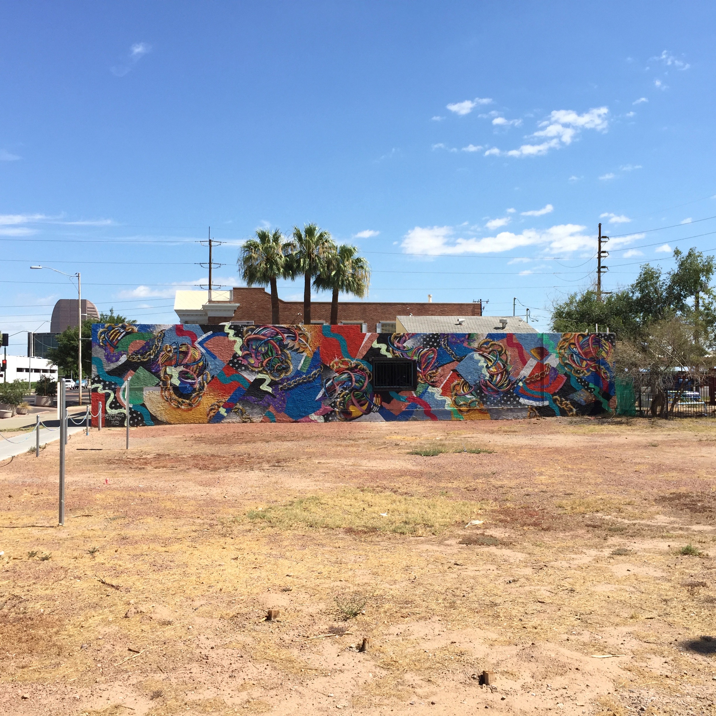 A messy mural in the sea of empty lots south of Hance Park.