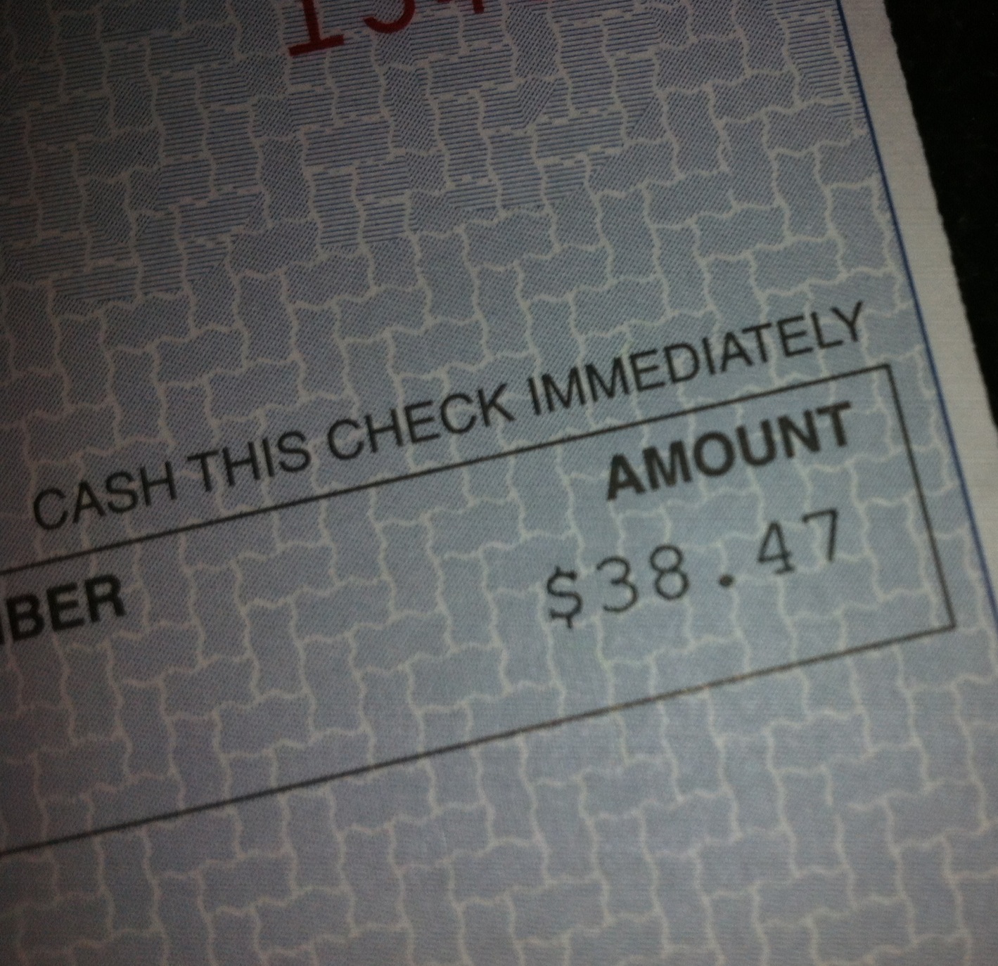 Photograph of a portion of a check showing the amount line: $38.47.